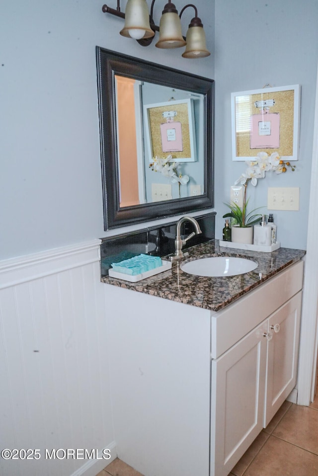 bathroom with vanity, tile patterned flooring, and an inviting chandelier