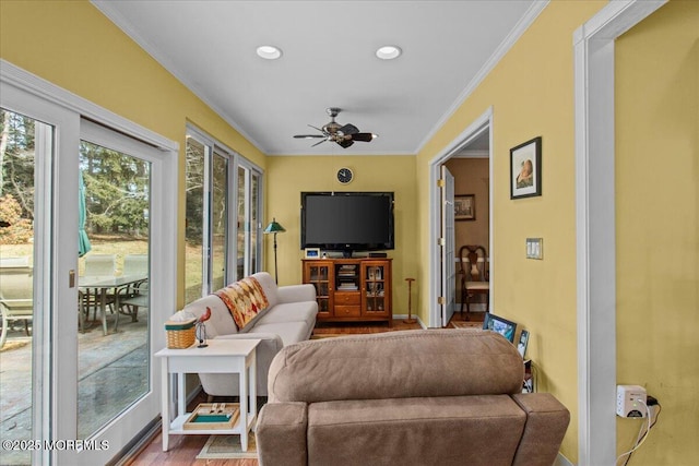 living area with ceiling fan, ornamental molding, wood finished floors, and baseboards