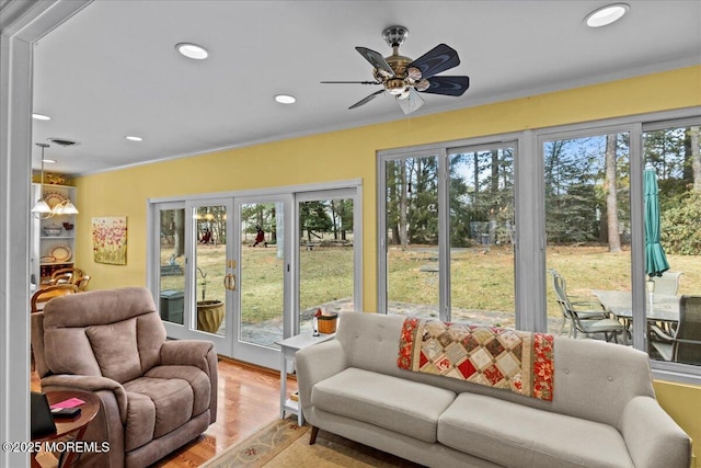 sunroom / solarium featuring a healthy amount of sunlight, ceiling fan, and french doors