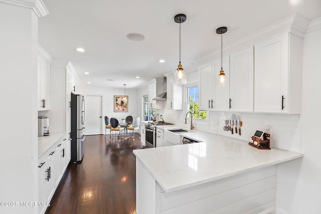 kitchen featuring kitchen peninsula, appliances with stainless steel finishes, and decorative light fixtures