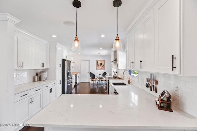 kitchen featuring sink, kitchen peninsula, hanging light fixtures, and white cabinets