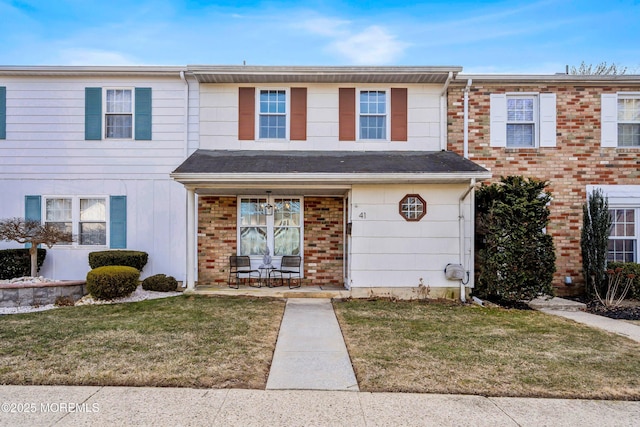 multi unit property with brick siding and a front lawn