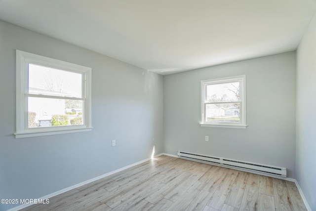 unfurnished room featuring baseboards, light wood-type flooring, and baseboard heating