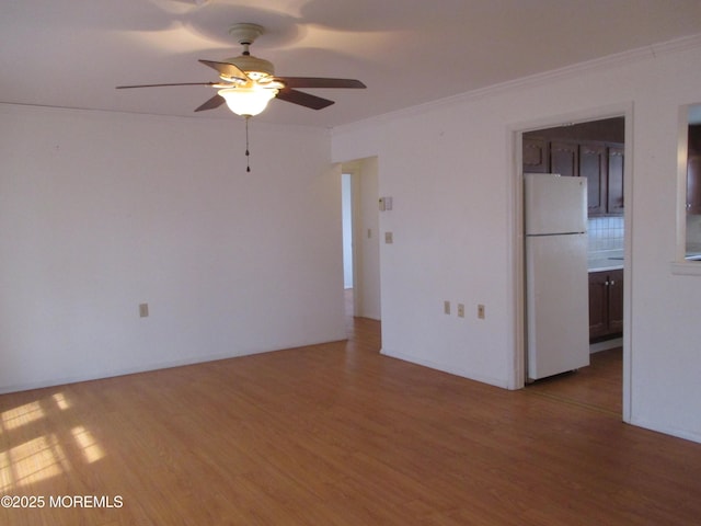 empty room with hardwood / wood-style flooring, crown molding, and ceiling fan