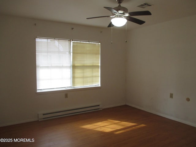 empty room with hardwood / wood-style flooring, ceiling fan, and a baseboard heating unit