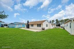 rear view of property with a lawn and a patio