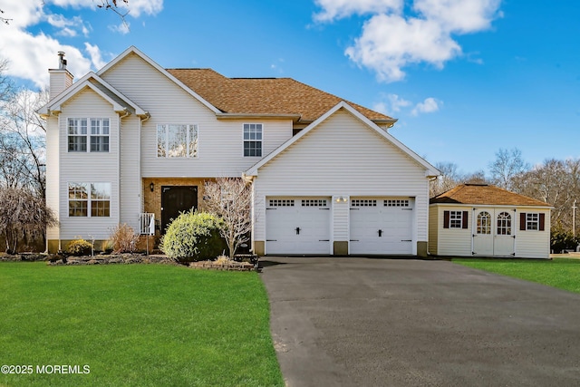 view of front facade featuring driveway, a chimney, an attached garage, and a front yard