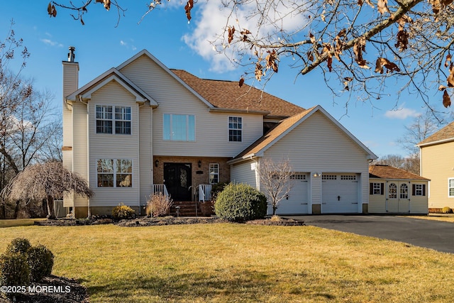 view of front of property featuring driveway, central AC unit, a chimney, an attached garage, and a front lawn