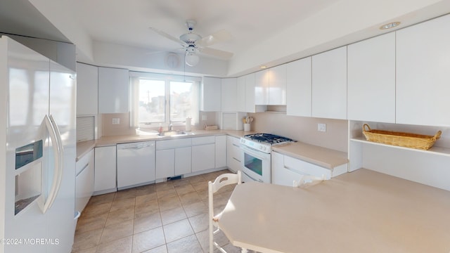 kitchen with white cabinetry, sink, white appliances, ceiling fan, and light tile patterned flooring