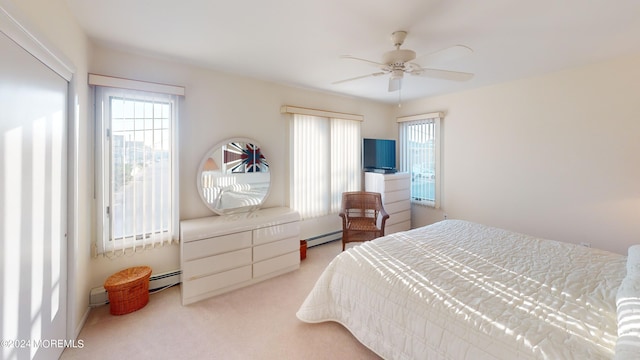 bedroom with a baseboard radiator, multiple windows, and light colored carpet