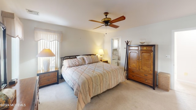 carpeted bedroom with ensuite bathroom and ceiling fan