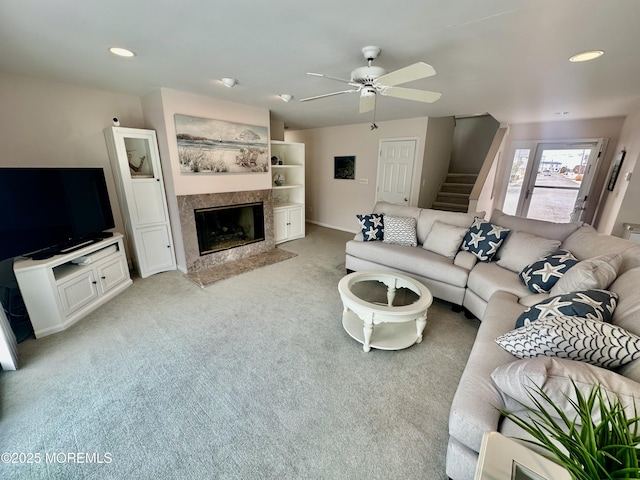 carpeted living room with ceiling fan and a premium fireplace