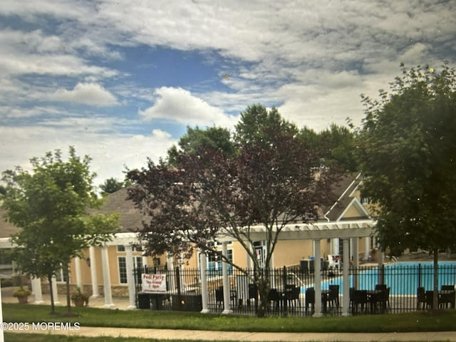 view of property featuring fence and a community pool