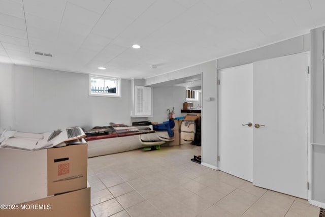 basement with light tile patterned floors, visible vents, and recessed lighting