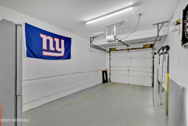 garage featuring freestanding refrigerator and a garage door opener