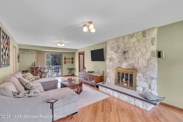 living room with a fireplace, baseboards, and wood finished floors