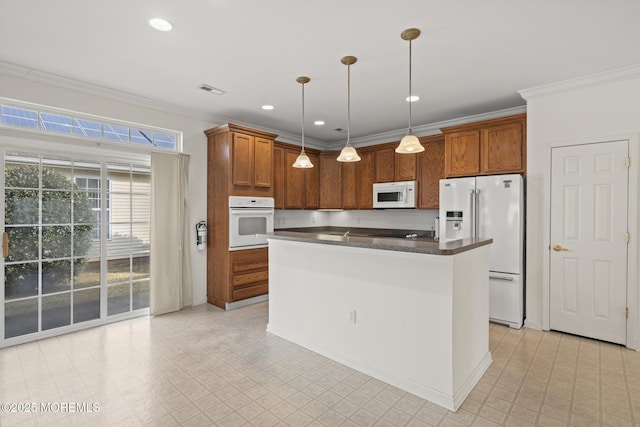 kitchen featuring white appliances, dark countertops, a kitchen island, light floors, and pendant lighting