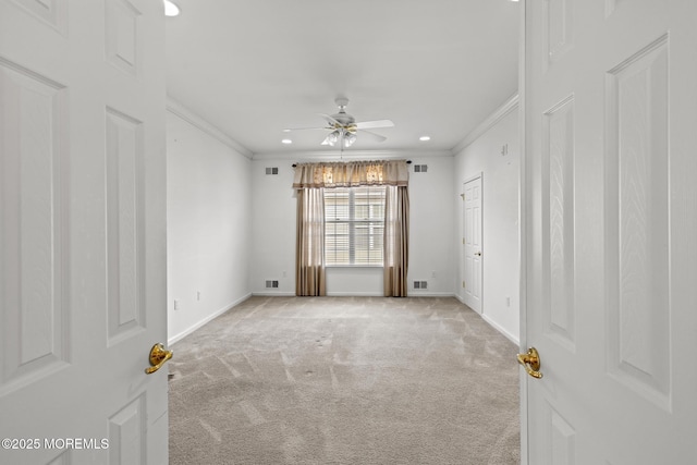 unfurnished room with light carpet, crown molding, visible vents, and baseboards