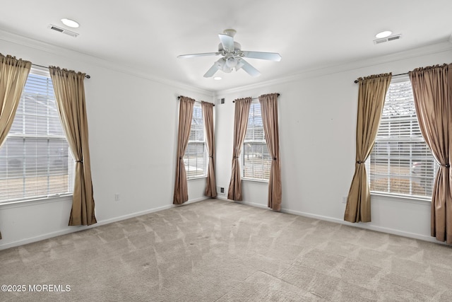 spare room featuring ornamental molding, a healthy amount of sunlight, and light carpet