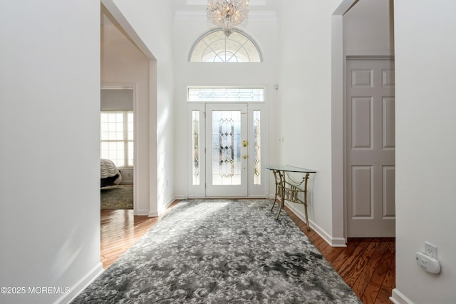 entrance foyer with dark wood-type flooring, a high ceiling, and a chandelier