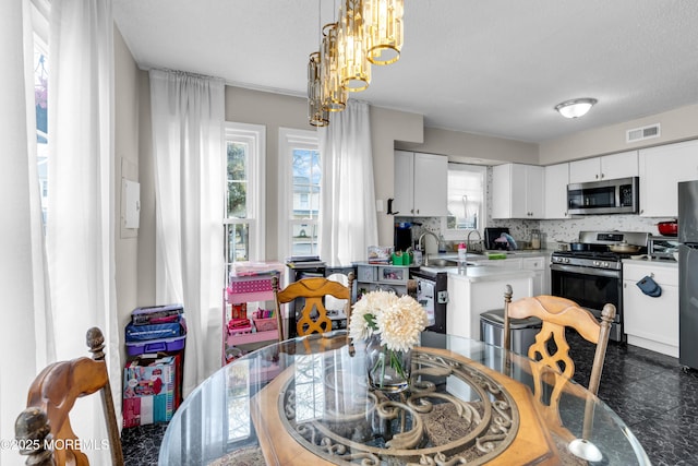 dining room featuring an inviting chandelier, visible vents, and a textured ceiling