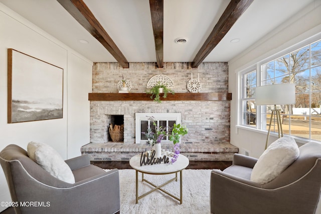 living room with beamed ceiling and a fireplace