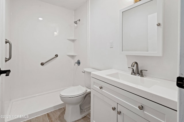 bathroom featuring a shower, toilet, hardwood / wood-style flooring, and vanity