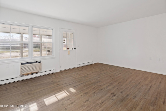 interior space with a baseboard heating unit, an AC wall unit, and dark hardwood / wood-style floors