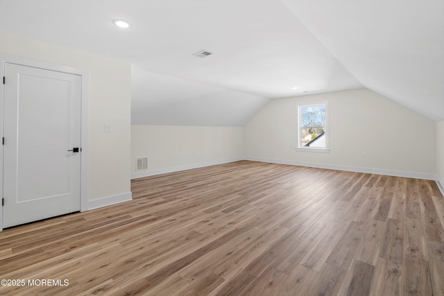 bonus room featuring vaulted ceiling and light hardwood / wood-style flooring