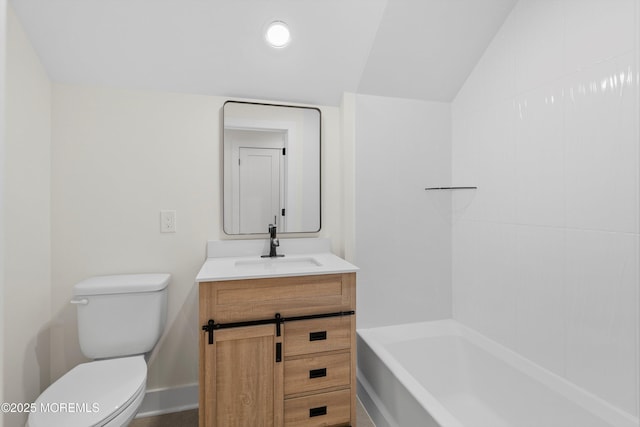 bathroom featuring vanity, toilet, a bath, and lofted ceiling