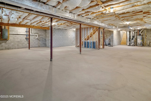 basement featuring electric panel, water heater, and heating unit