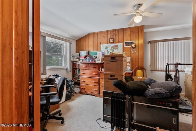 office with ceiling fan, lofted ceiling, wood walls, and carpet floors