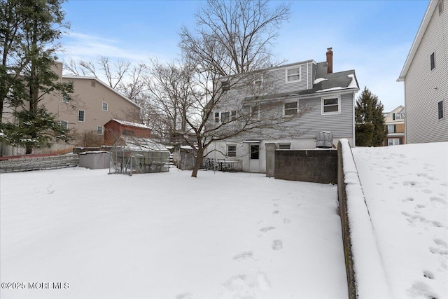 view of snow covered back of property