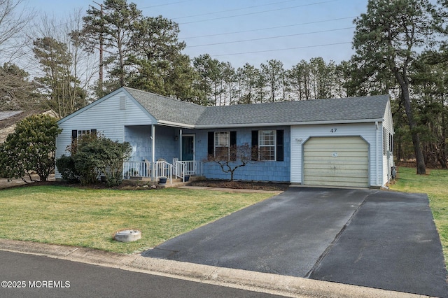 ranch-style home featuring covered porch, a front lawn, and a garage