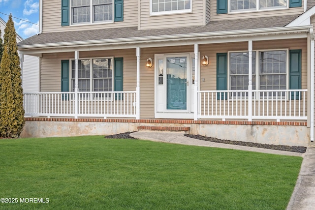 property entrance with covered porch and a yard