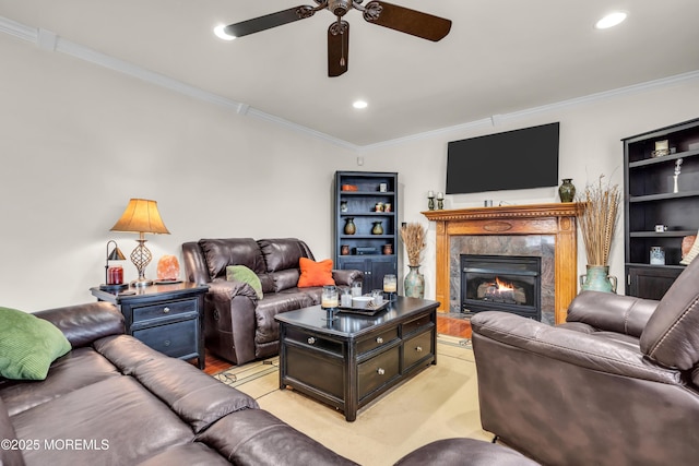 living room featuring a fireplace, ornamental molding, light carpet, and ceiling fan