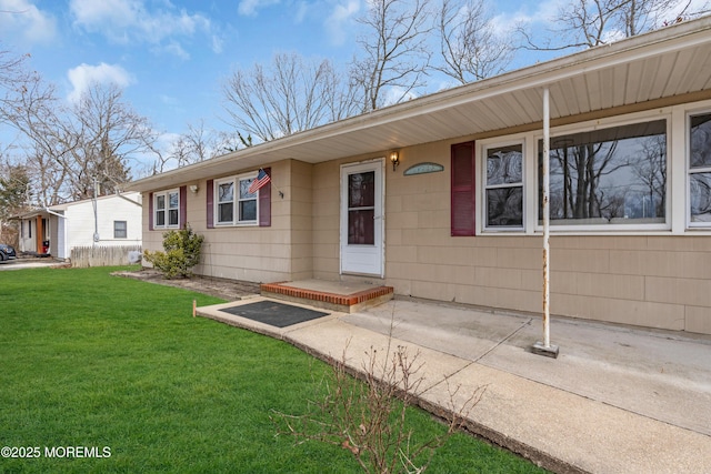 view of exterior entry featuring a lawn