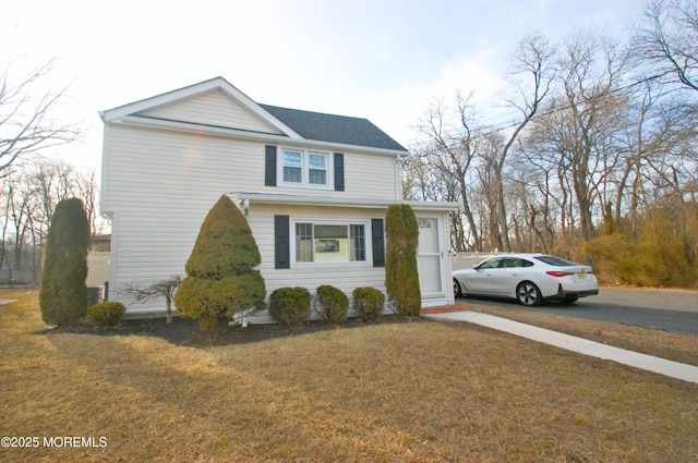 traditional-style house with driveway and a front yard