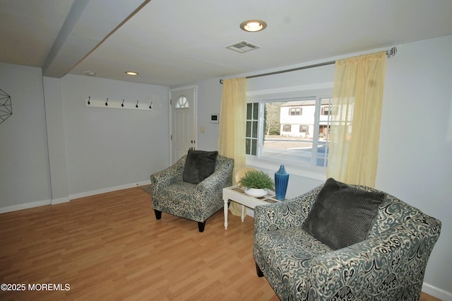 sitting room featuring baseboards, visible vents, and wood finished floors