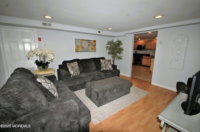 living room with light wood-style flooring, visible vents, recessed lighting, and baseboards