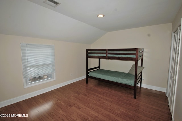 bedroom with dark wood finished floors, baseboards, visible vents, and lofted ceiling