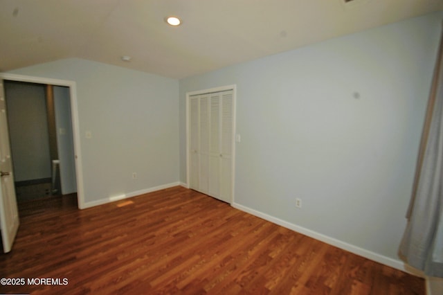 unfurnished bedroom featuring baseboards, vaulted ceiling, dark wood finished floors, a closet, and recessed lighting