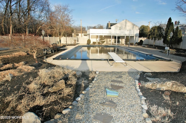 view of swimming pool featuring fence, a patio area, a diving board, and a fenced in pool