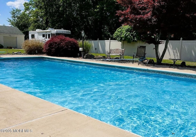 pool featuring an outbuilding and fence