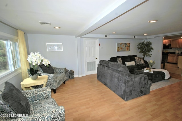 living room with light wood finished floors, baseboards, visible vents, and recessed lighting