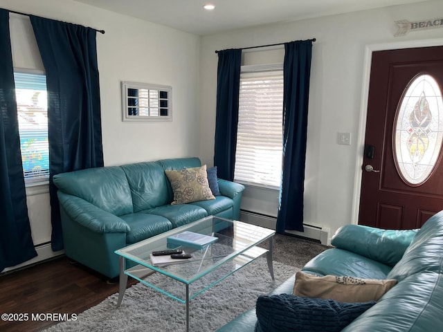 living room with a baseboard heating unit and dark wood-type flooring