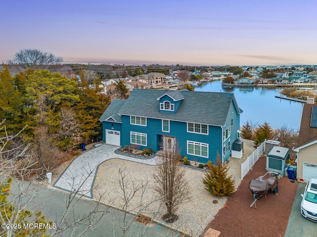 view of front of home with a garage and a water view