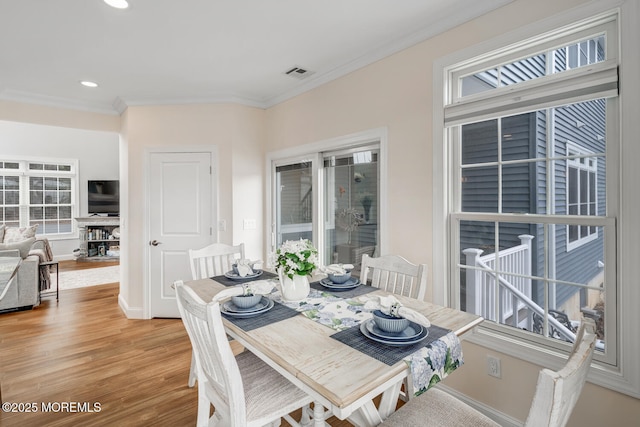 dining space with ornamental molding and wood-type flooring