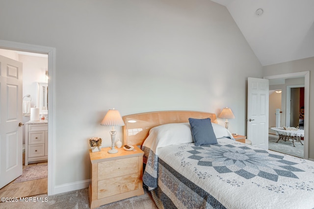 carpeted bedroom featuring vaulted ceiling and ensuite bathroom