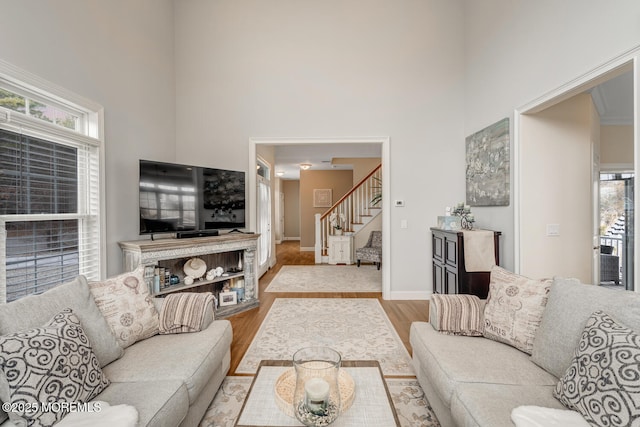 living room with light hardwood / wood-style flooring, plenty of natural light, and a high ceiling